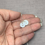 Tiny Sterling Silver Initial Necklace in hand to show size