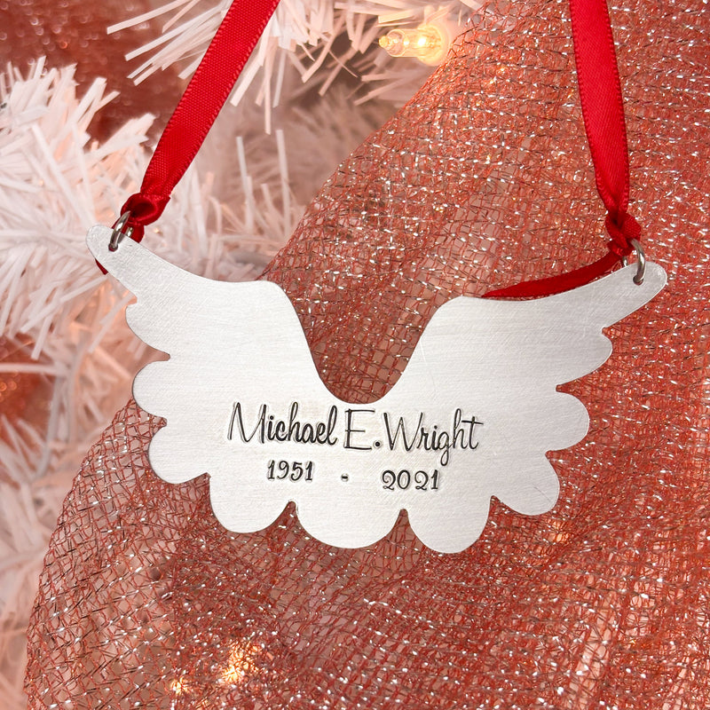 Memorial ornament with wings and engraved name and years.