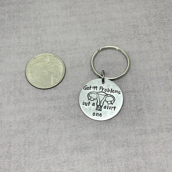 I've got 99 problems but a Uterus ain't one keychain next to quarter for size comparison