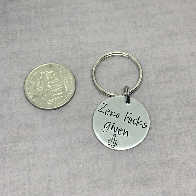 Zero Fucks Given keychain, Funny keychain next to quarter for size comparison