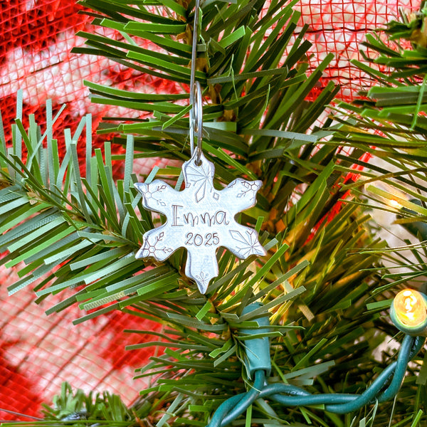 Small snowflake ornament with 1 name and date on a Christmas tree.