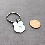 police badge key chain next to penny to show size