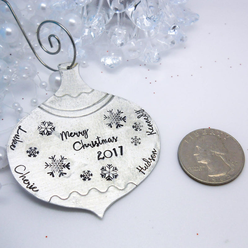 Pewter personalized vintage Christmas ornament next to a quarter for size comparison